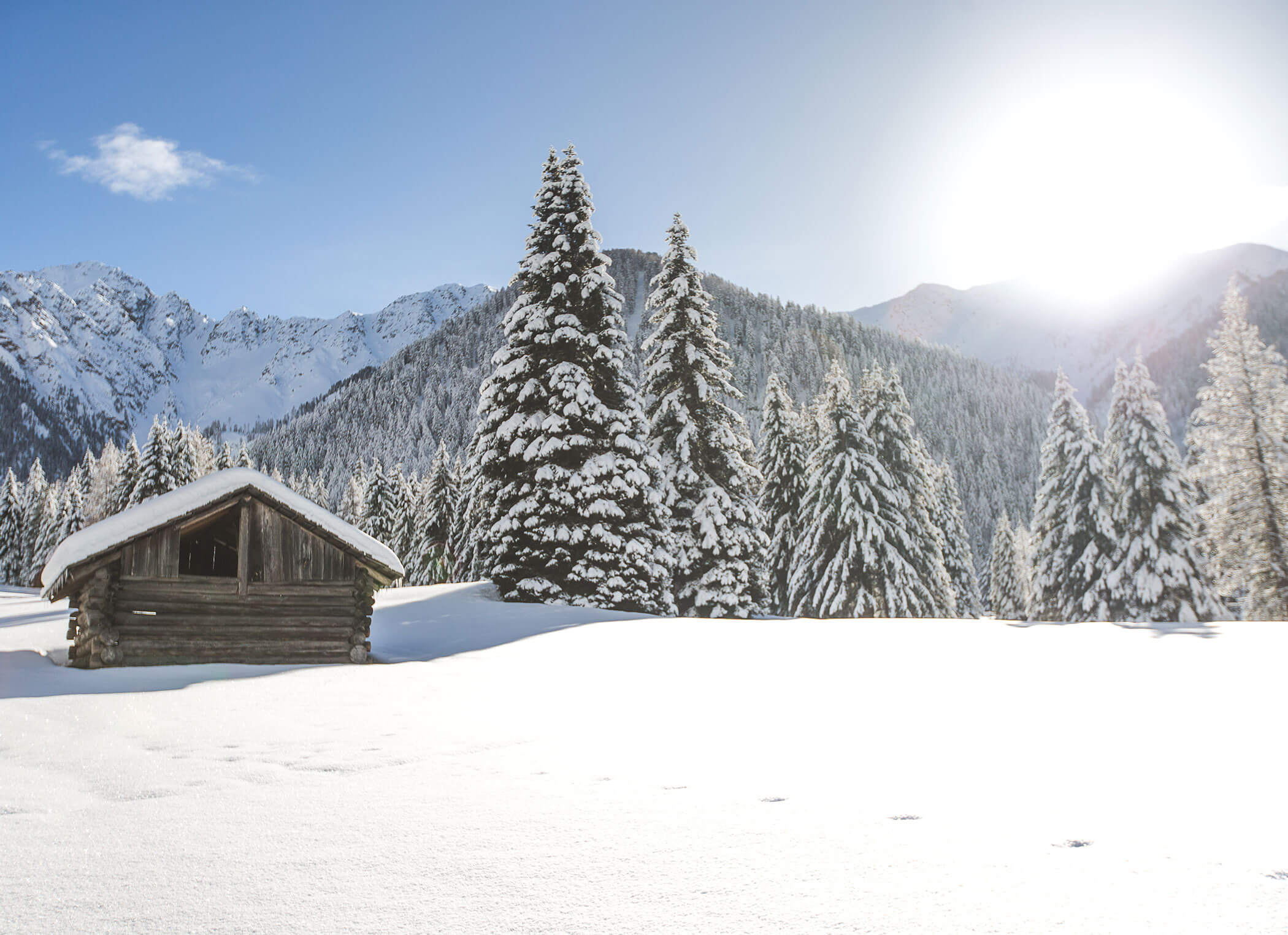 Alte Almhütte auf tief verschneiter Bergwiese